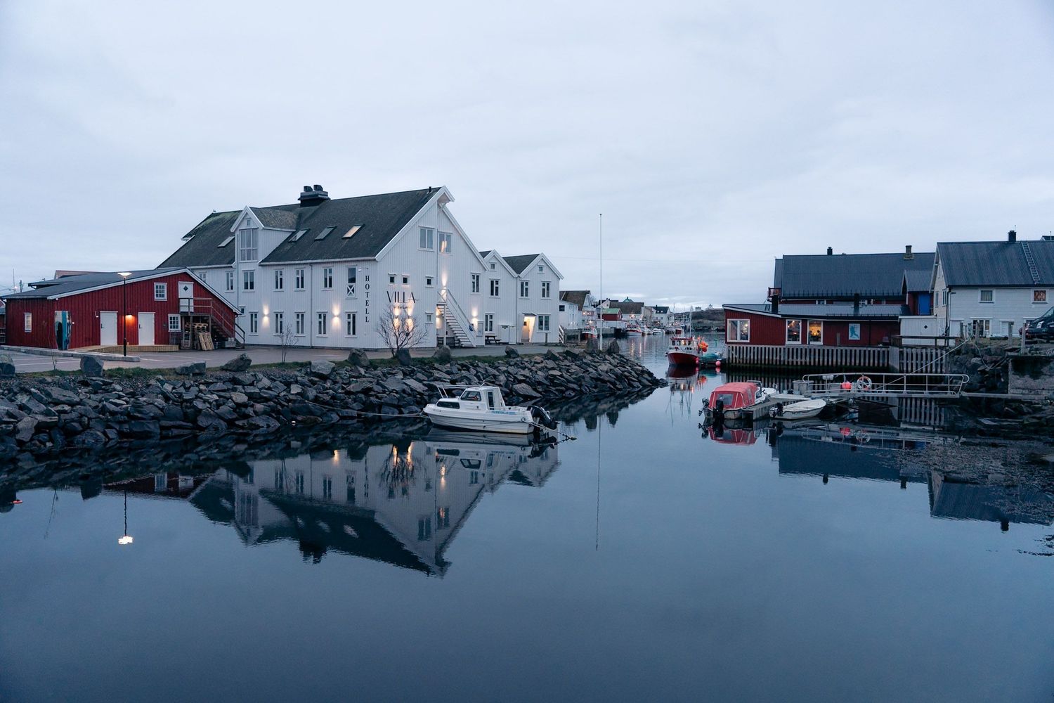 port d'henningsvaer à la tombée de la nuit avec reflet dans les eaux du fjord