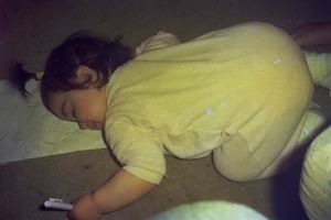 Person sleeping peacefully in yellow pajamas on a comfortable surface.