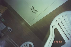 Interior view of a room with white plastic chairs and walls.