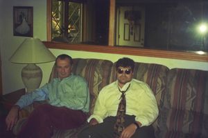 People relaxing on a couch in a dimly lit living room setting.