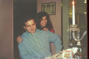 A candlelit dinner scene with a couple sitting at a table.