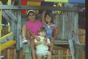 Children playing on colorful outdoor playground equipment with slides and climbing structures.