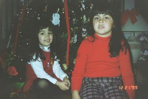 Children dressed in holiday attire sitting together during what appears to be a Christmas celebration.