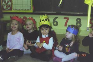 Students sitting in a classroom with numbers and educational materials visible on the wall.