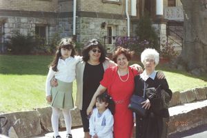 Group gathered outdoors near a brick building on a sunny spring day.