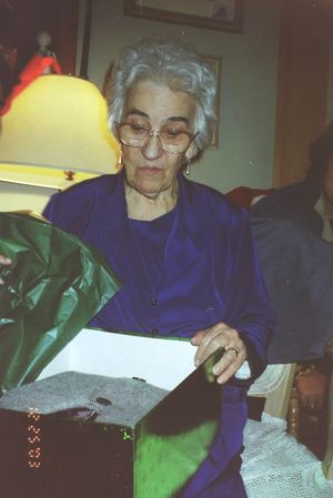 Person in blue clothing sitting at a table with white lace tablecloth.