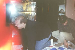 Group gathering in a dimly lit room with red lighting.