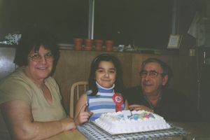 Family gathering around a birthday cake with decorations.