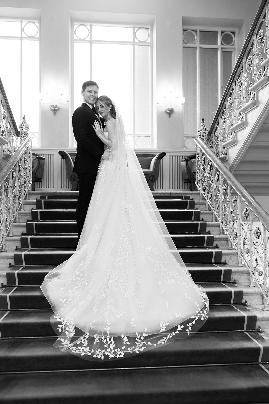 A sequence of wedding photos showing a bride descending an elegant staircase with ornate railings in a grand venue.