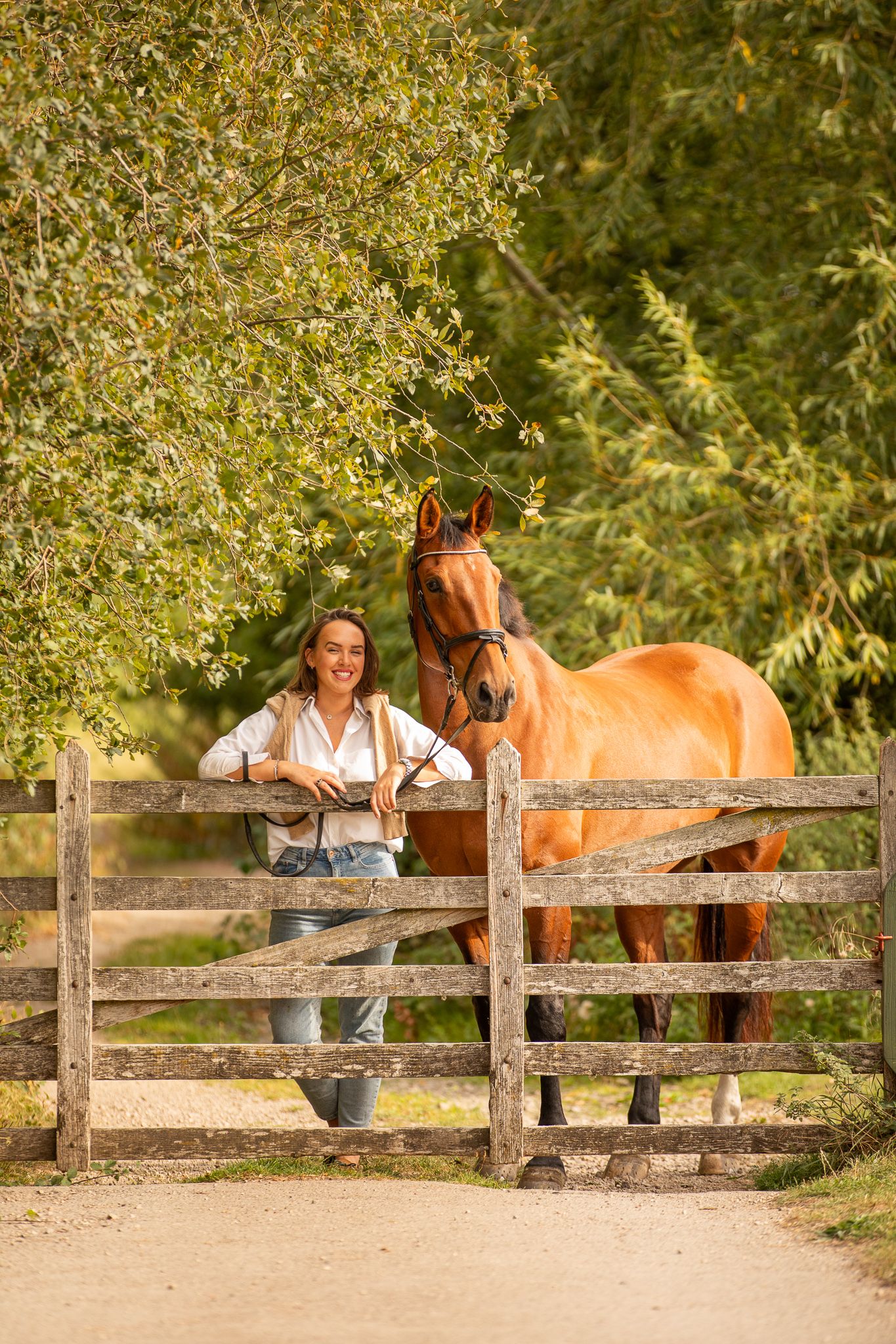 Young equestrian poses with palomino pony in a series of natural outdoor portraits showing their special bond.