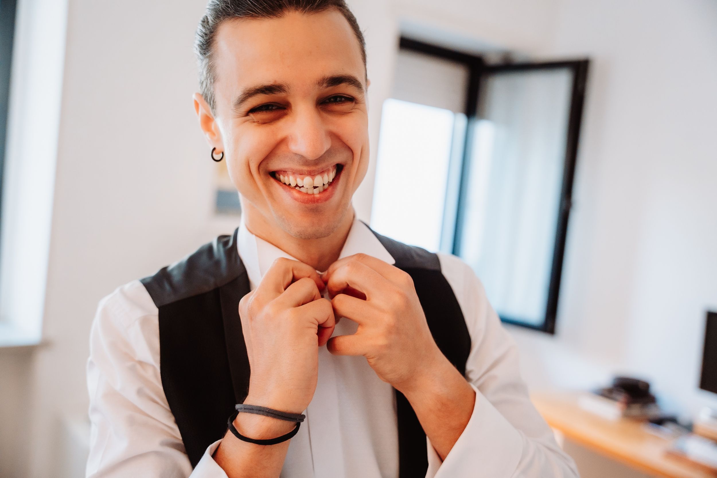 Professional in a white shirt smiles while sitting at a modern office desk during a business meeting.