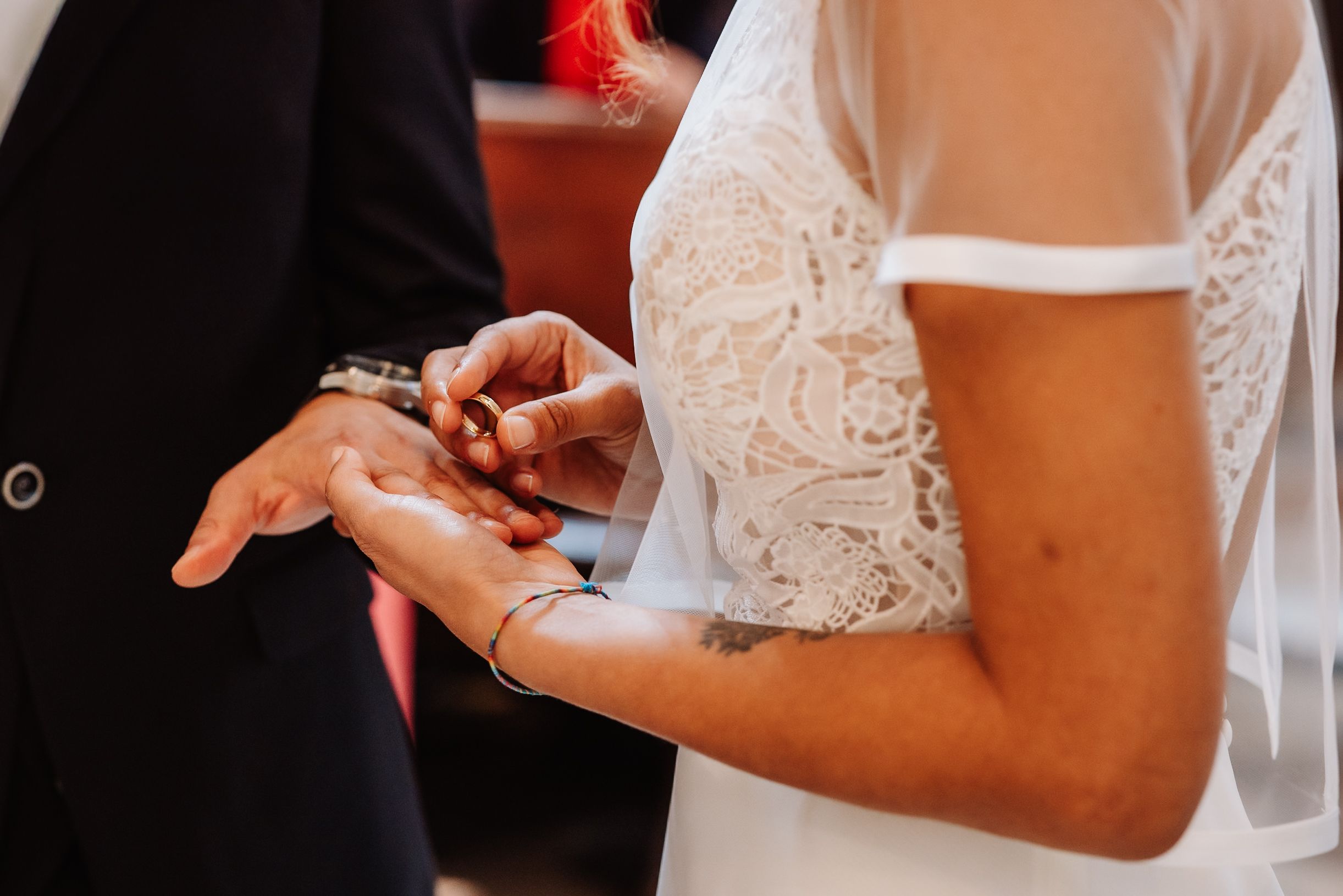 Close-up shot of hands exchanging wedding rings during an intimate ceremony.