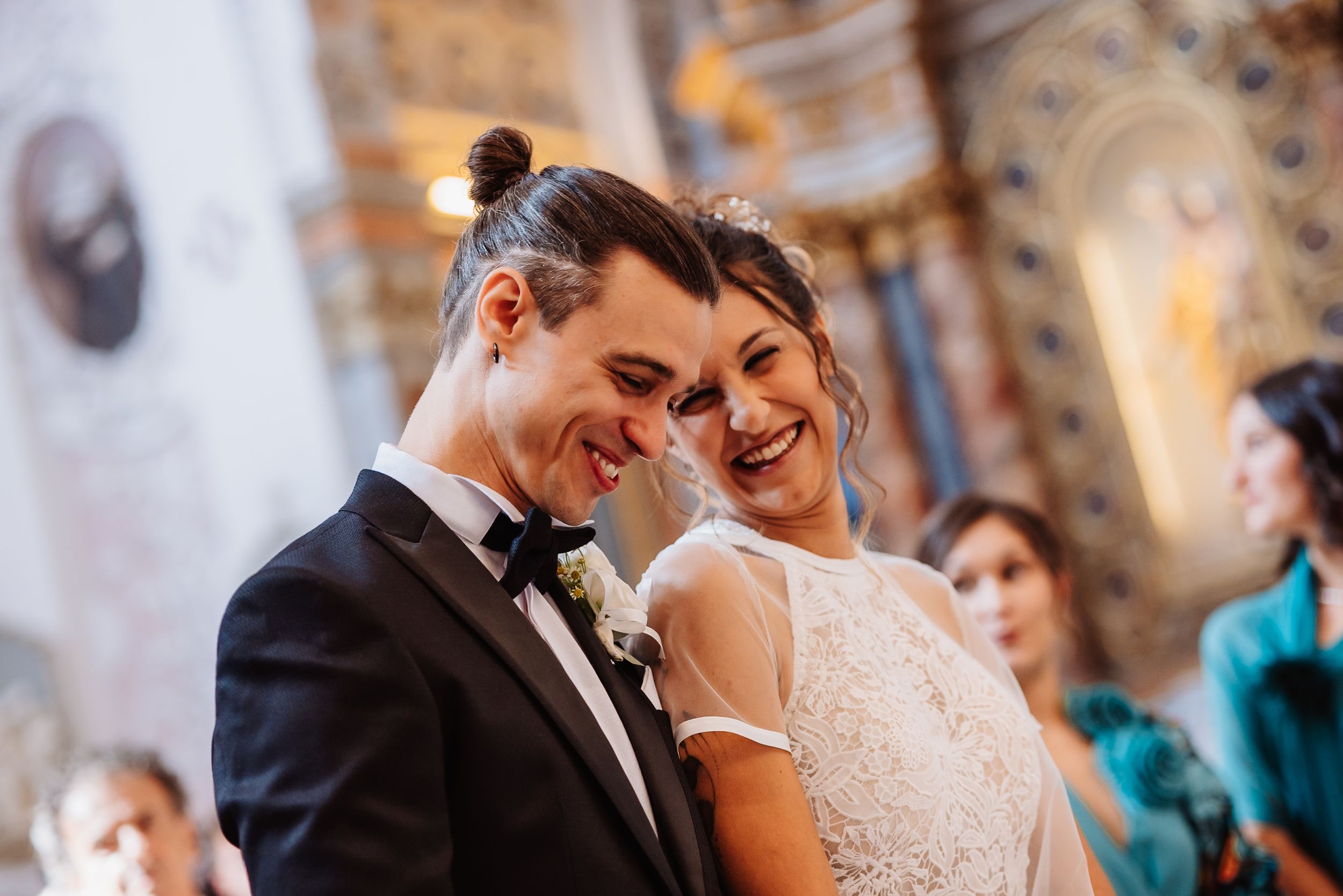 A couple shares an intimate moment during their wedding ceremony in an elegant church setting.