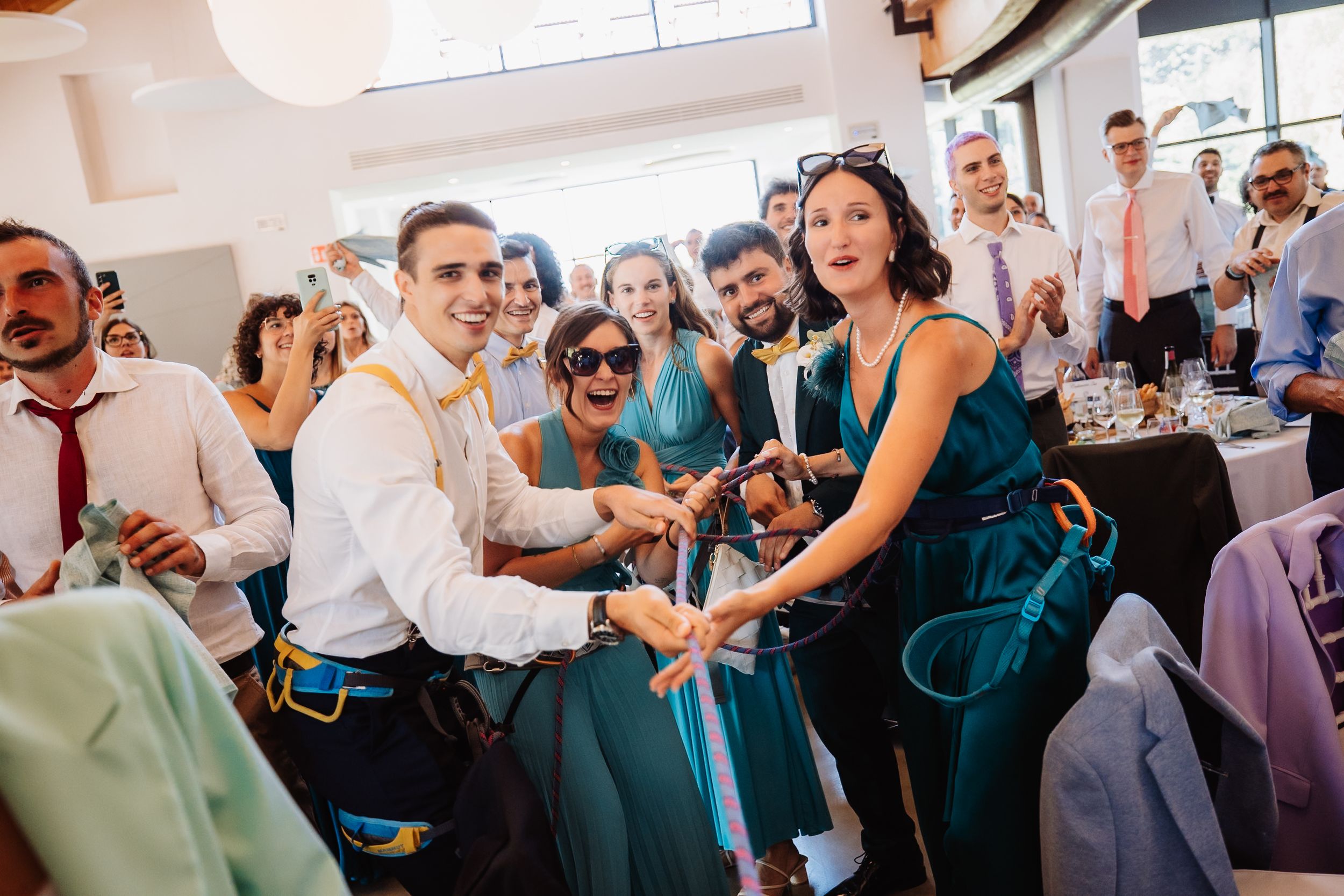 Wedding guests dance and celebrate on a crowded dance floor during a lively reception party.