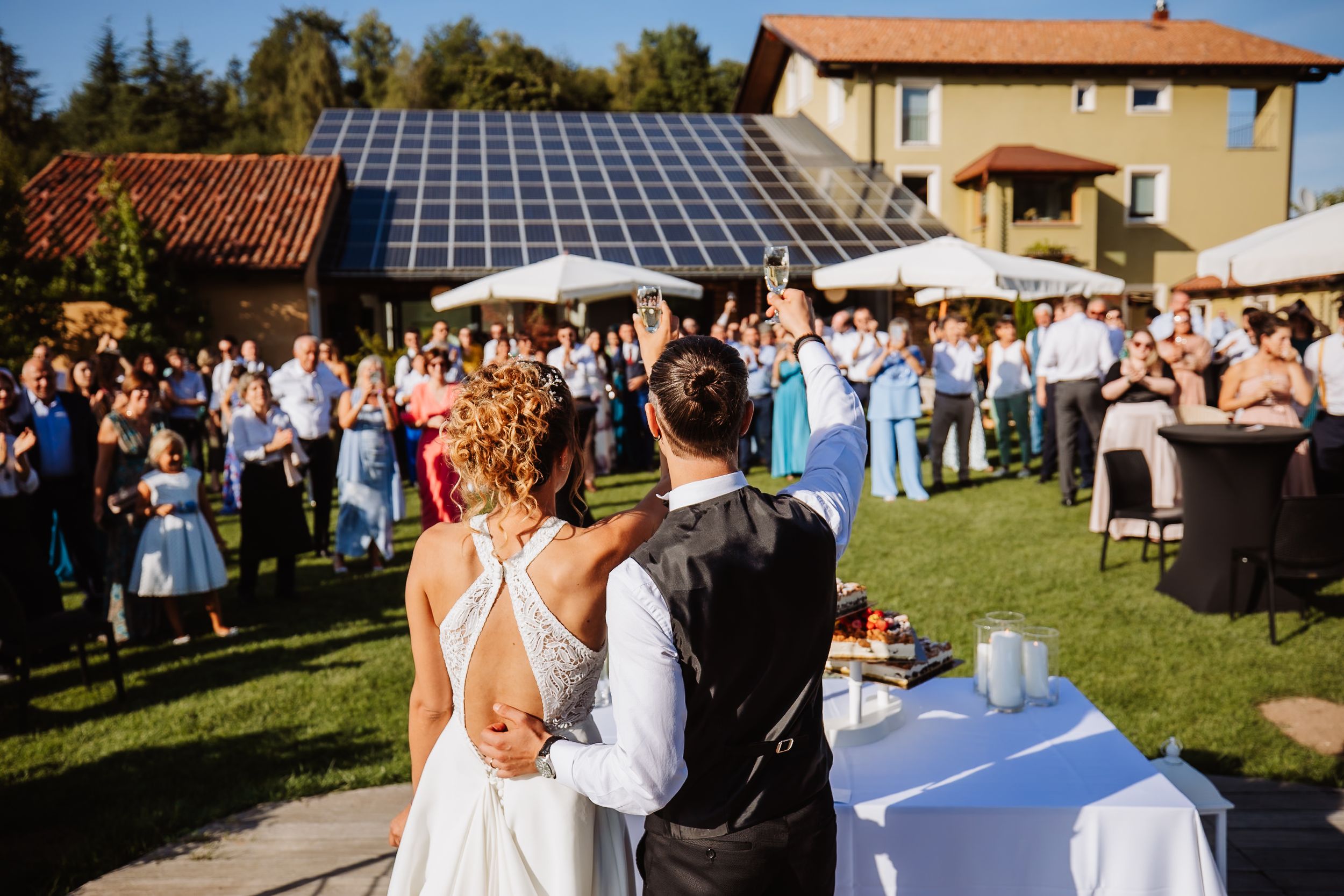 Elegant outdoor wedding reception setup with tables and chairs on a lawn with mountain scenery in the background.