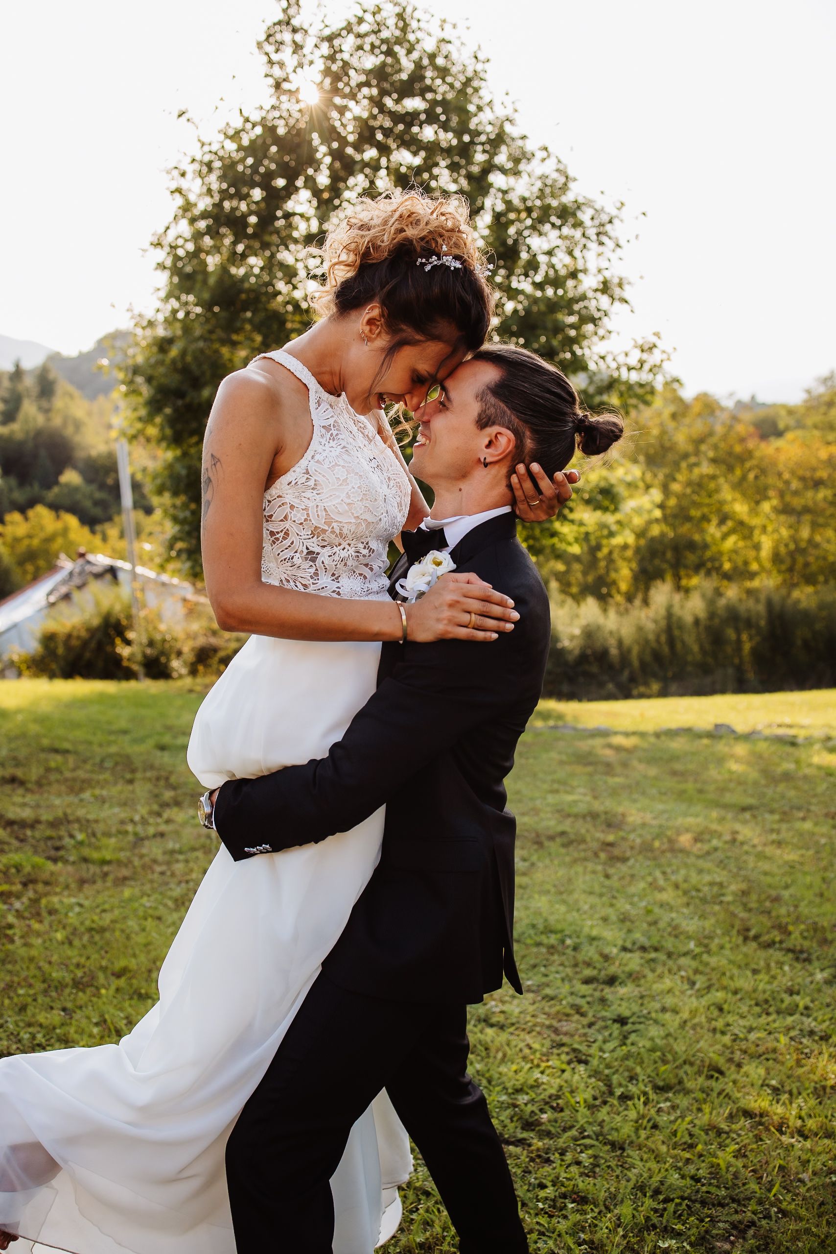 A romantic couple embraces in a sun-drenched meadow during their wedding photoshoot.
