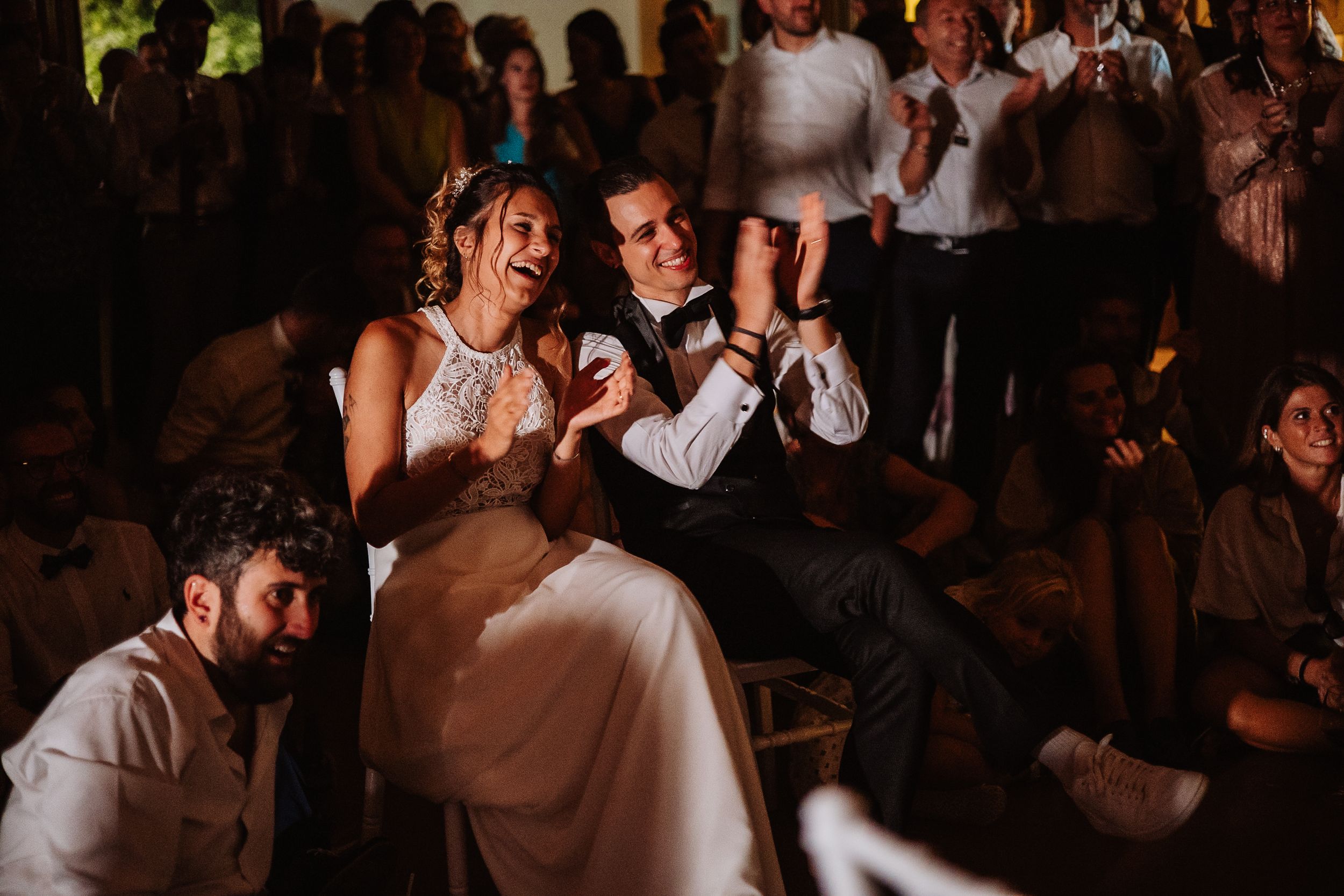 Newlyweds share a romantic dance together at their wedding reception while guests watch from the background.