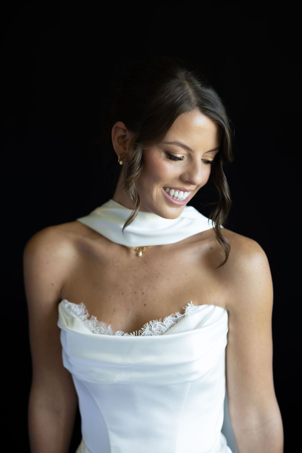 Close-up portrait shots of bride wearing an elegant white strapless wedding gown with lace details.