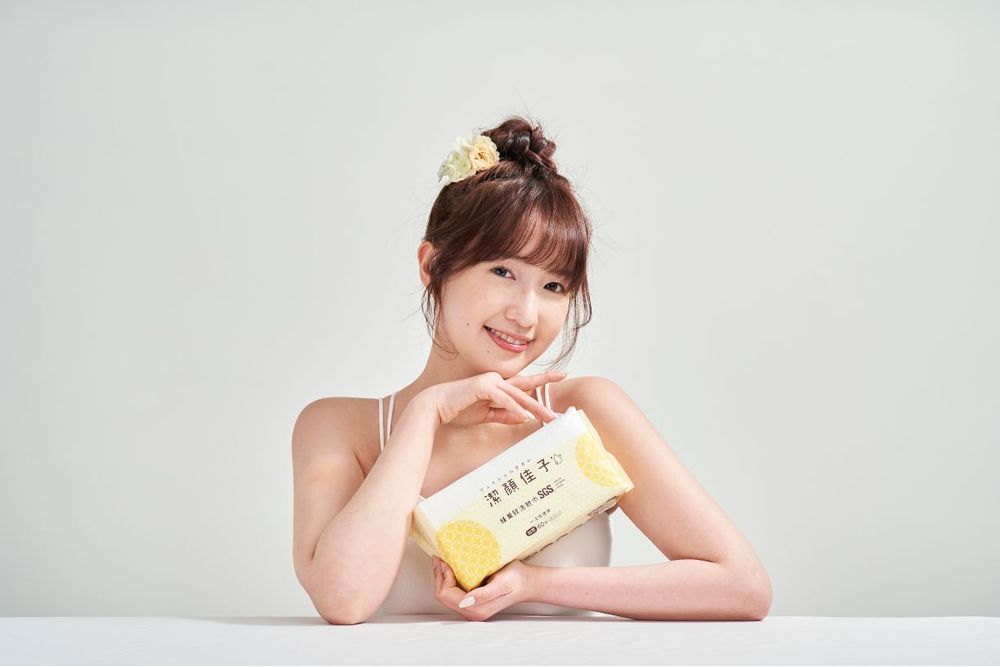 Person in casual attire poses with a yellow phone case in a bright studio setting.