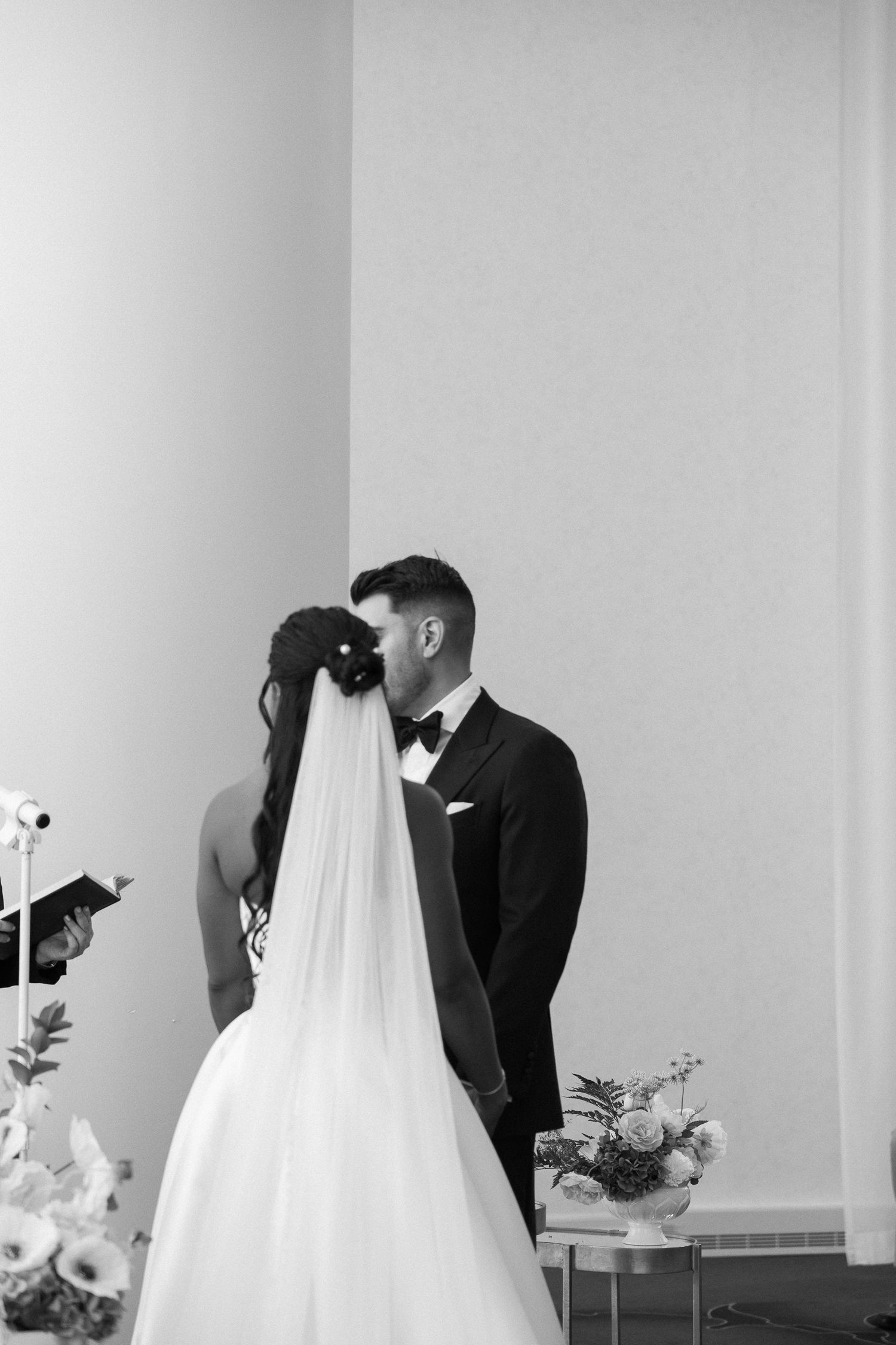 Interracial couple sharing joyful first dance at elegant wedding reception venue.
