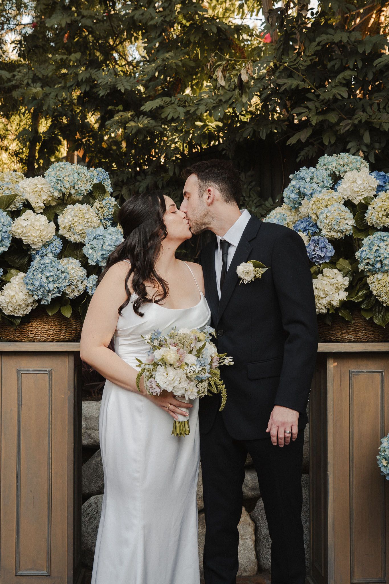 Bride and groom sharing a quiet intimate kiss at their outdoor wedding in Pasadena
