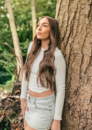 Girl leans against tree in the natural light