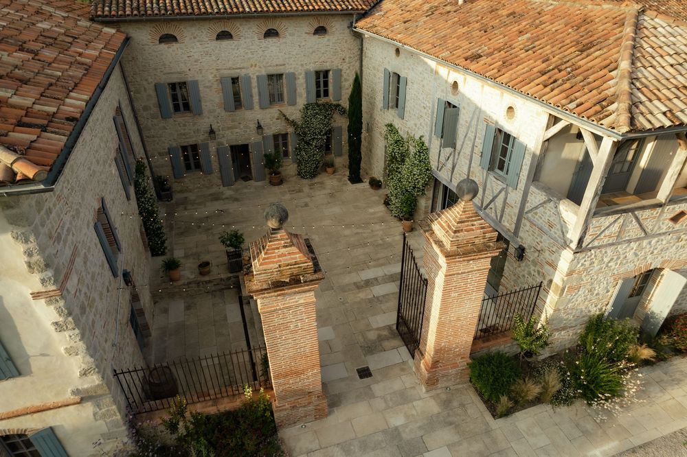 Aerial view of rustic Italian villa buildings with terracotta roofs.