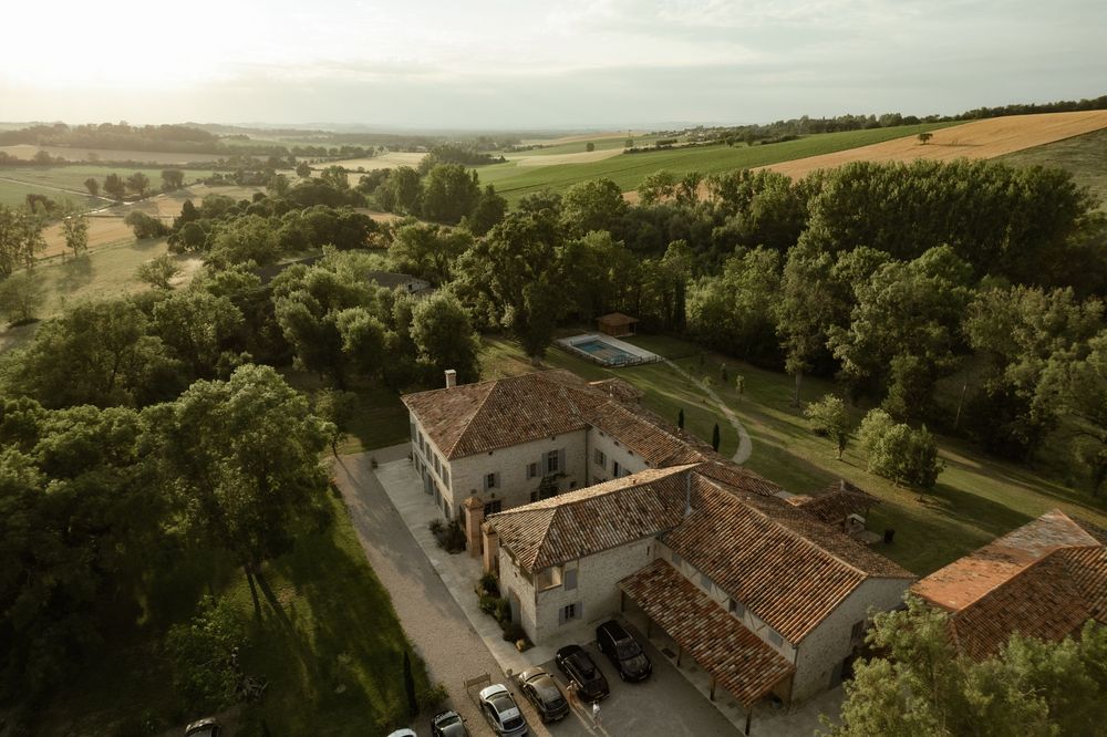 Panoramic countryside view of rolling hills and traditional buildings in rural France.