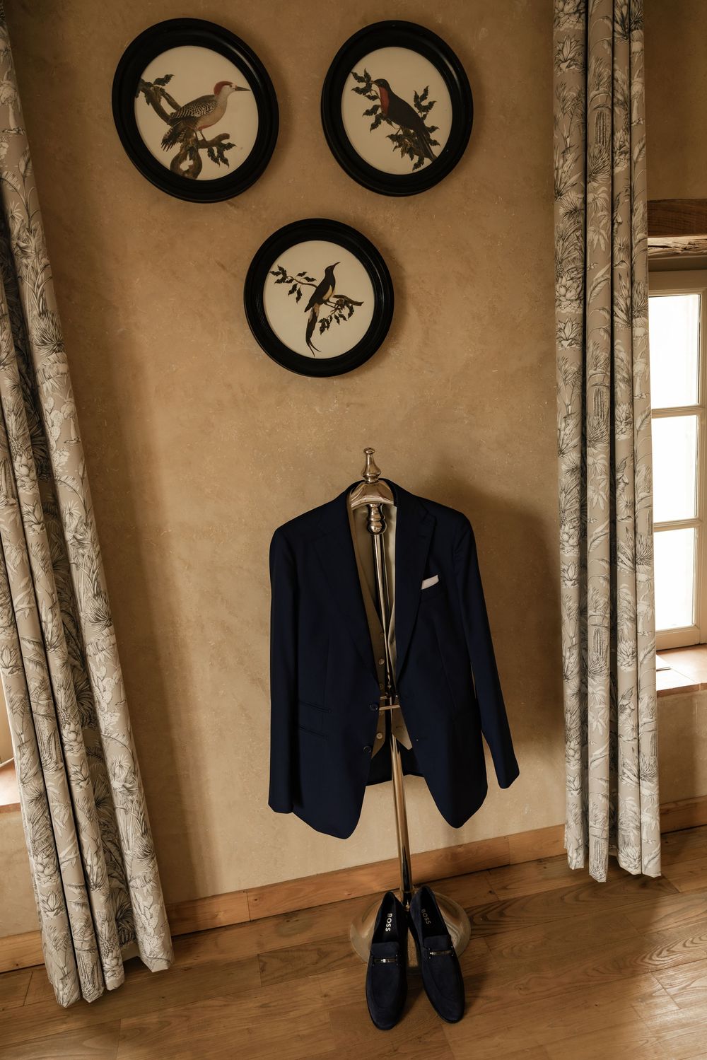 Navy blue suit jackets hanging on wall with decorative circular wall art.