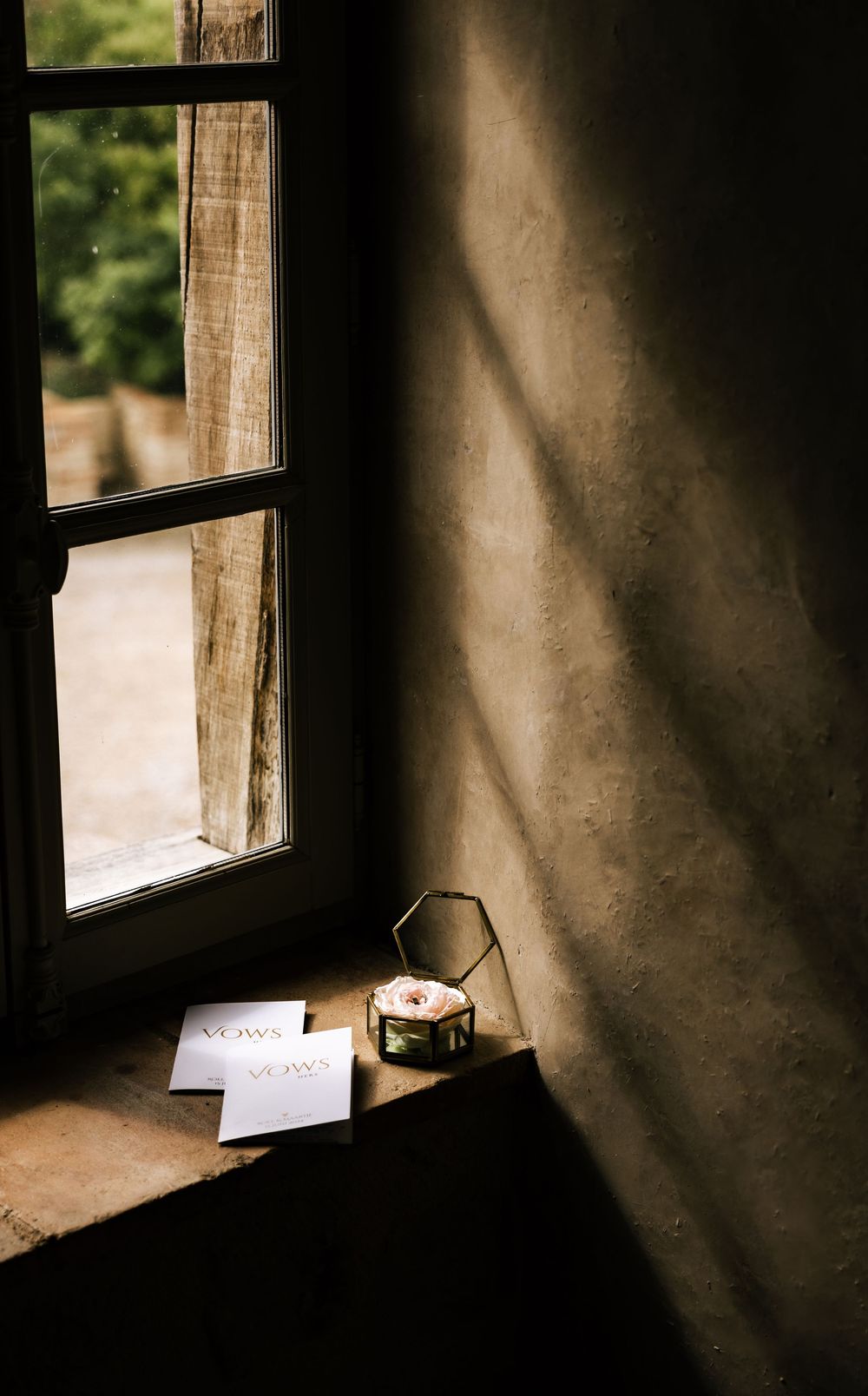Sunlight streaming through rustic window onto windowsill with paper.