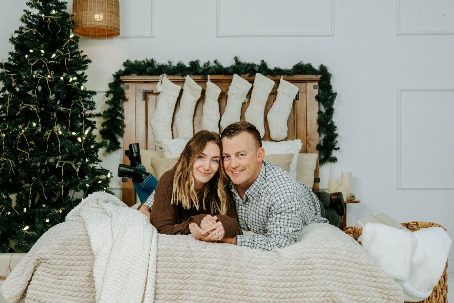 Cozy winter scene with couple cuddling near decorated Christmas tree and fireplace in living room.