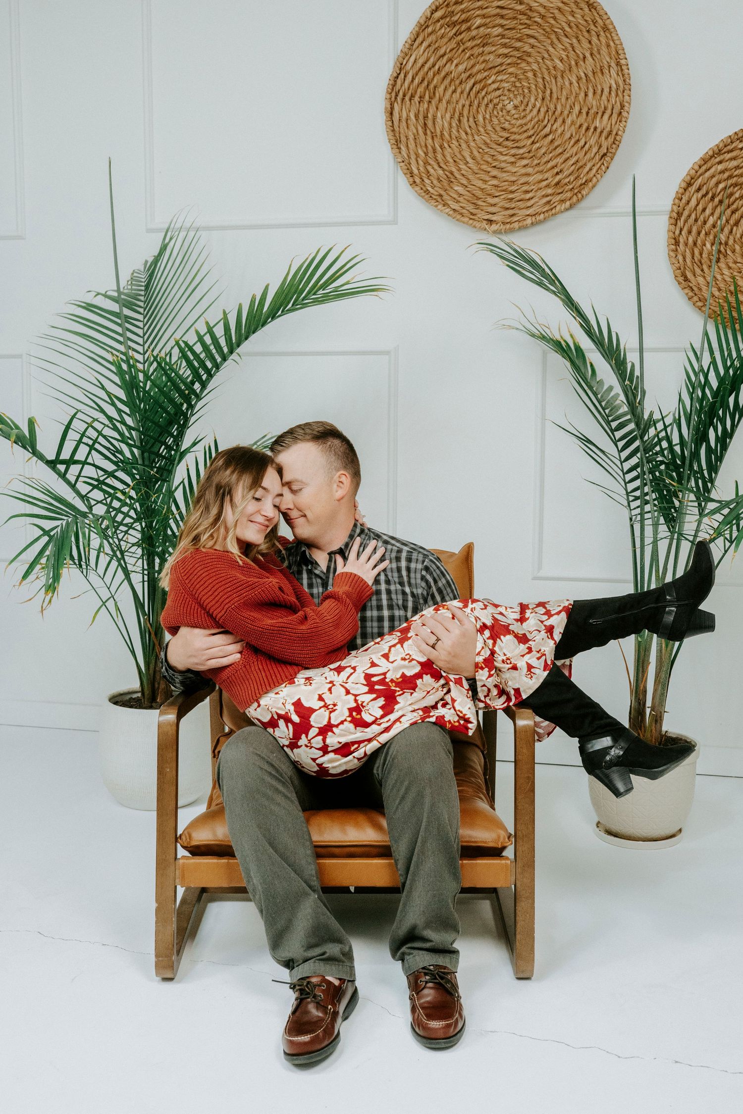 A series of four progressive photos showing a couple sitting on a wooden bench with woven wall decor and tropical plants.