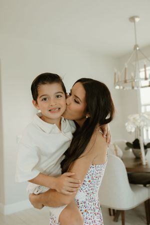 Sweet candid moments of family affection and embraces in a light-filled room.