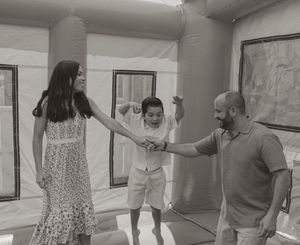 Playful sequence showing family members bouncing and having fun indoors.