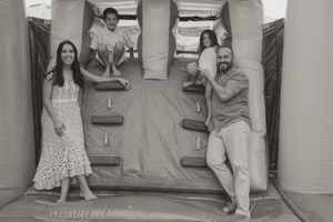 Family members enjoying active playtime together on an indoor bouncy surface.