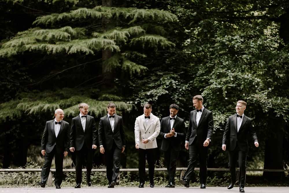 A sequence of wedding party photos shows groomsmen walking and posing together in a lush garden setting.