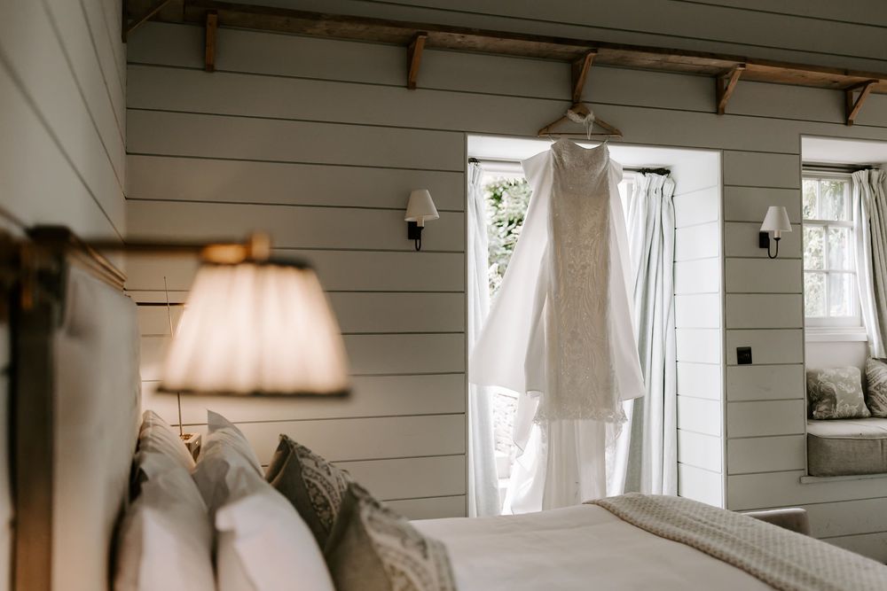 Rustic white shiplap walls and ceiling in a bright interior space with pendant lights and sheer curtains.