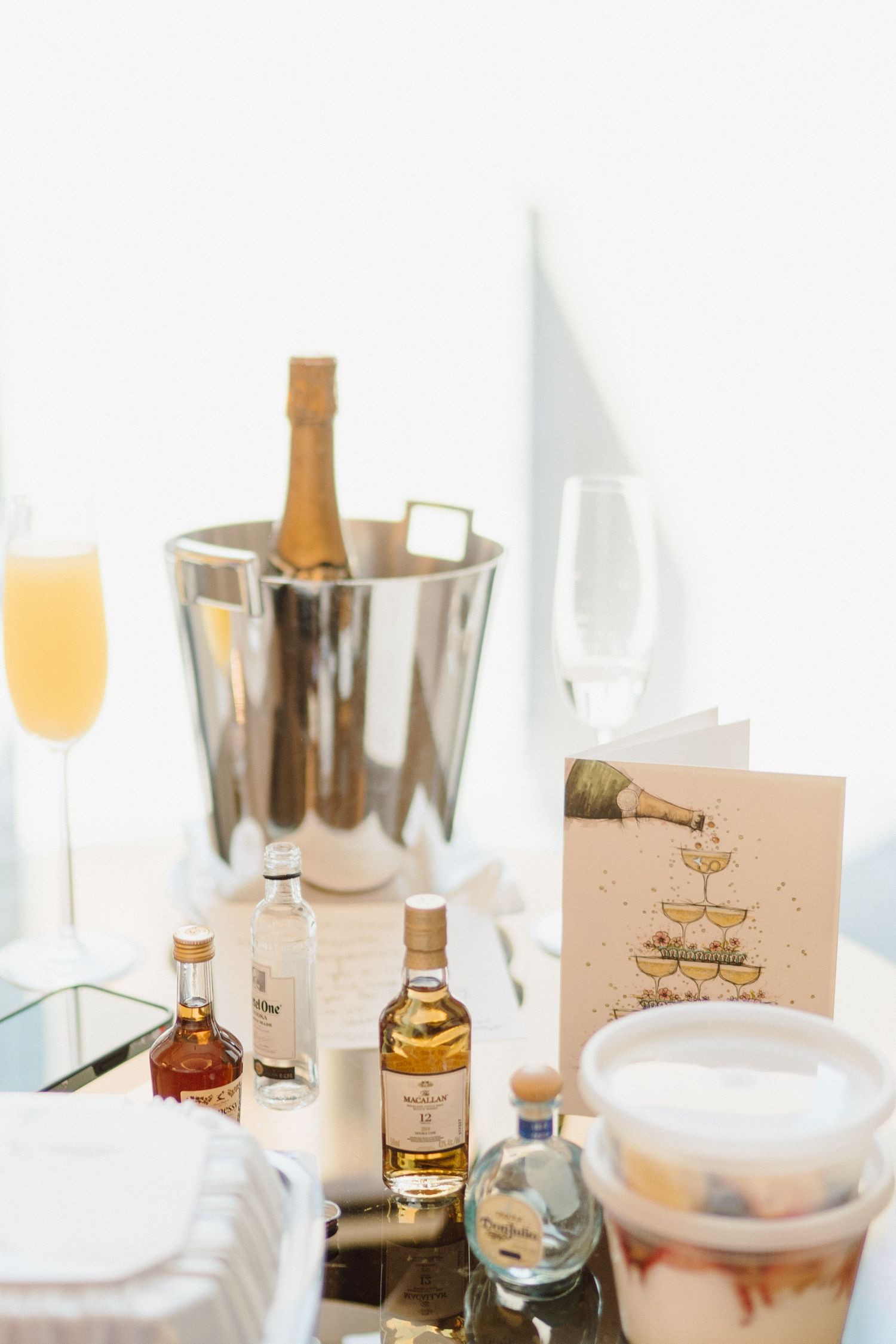 Wedding reception table setup with champagne bottles and place cards in soft lighting.