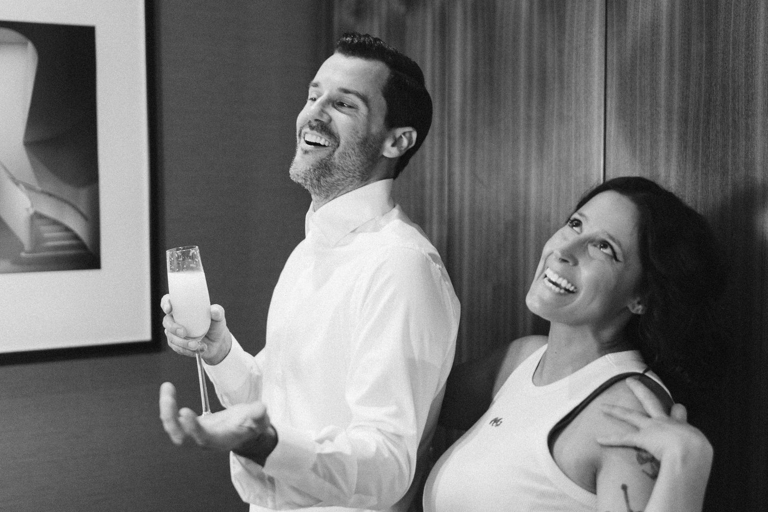 Black and white candid shots capturing joyful laughter and preparation moments.