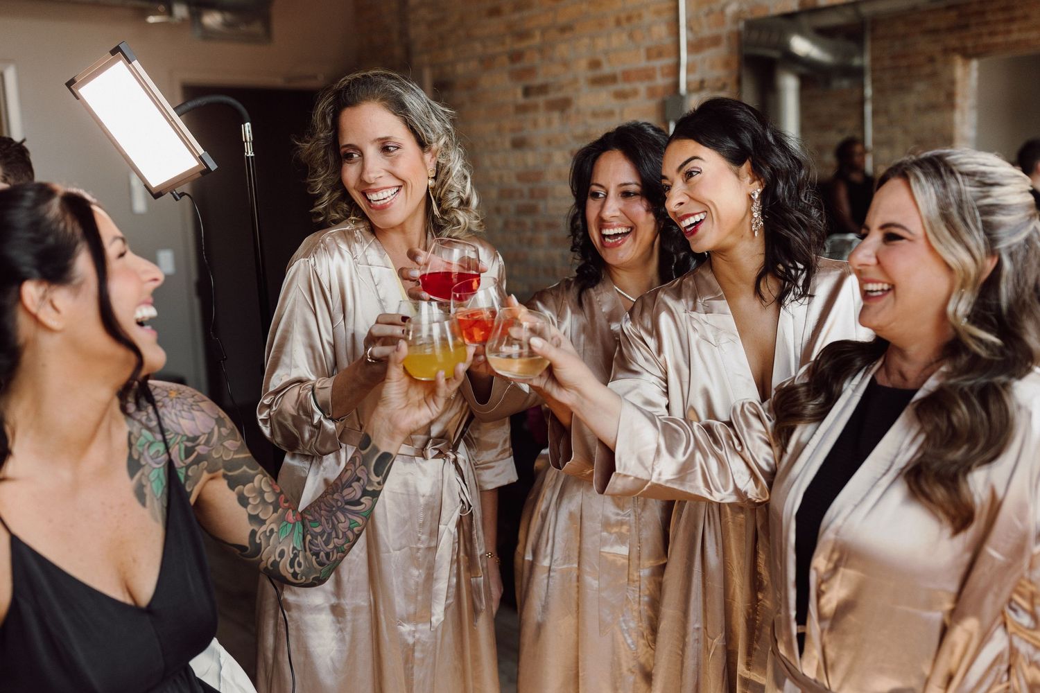 Group of friends enjoying drinks and laughing together at a celebration.