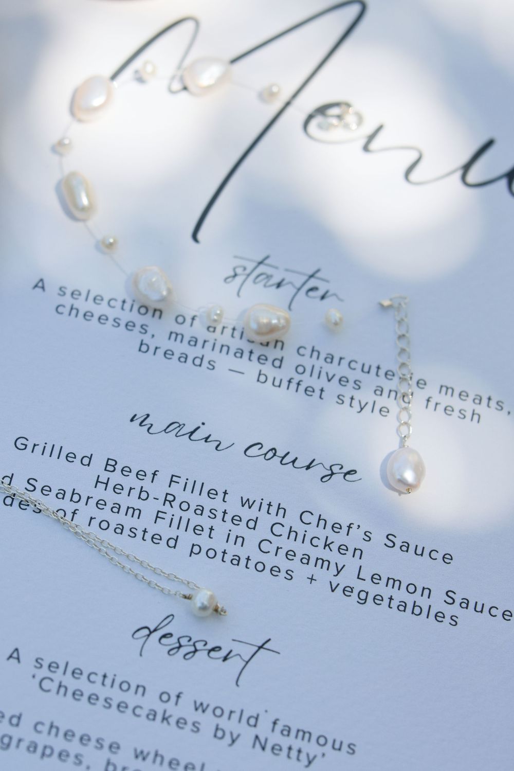 Close-up shot of an elegant wedding menu card with cursive text listing gourmet dinner courses.