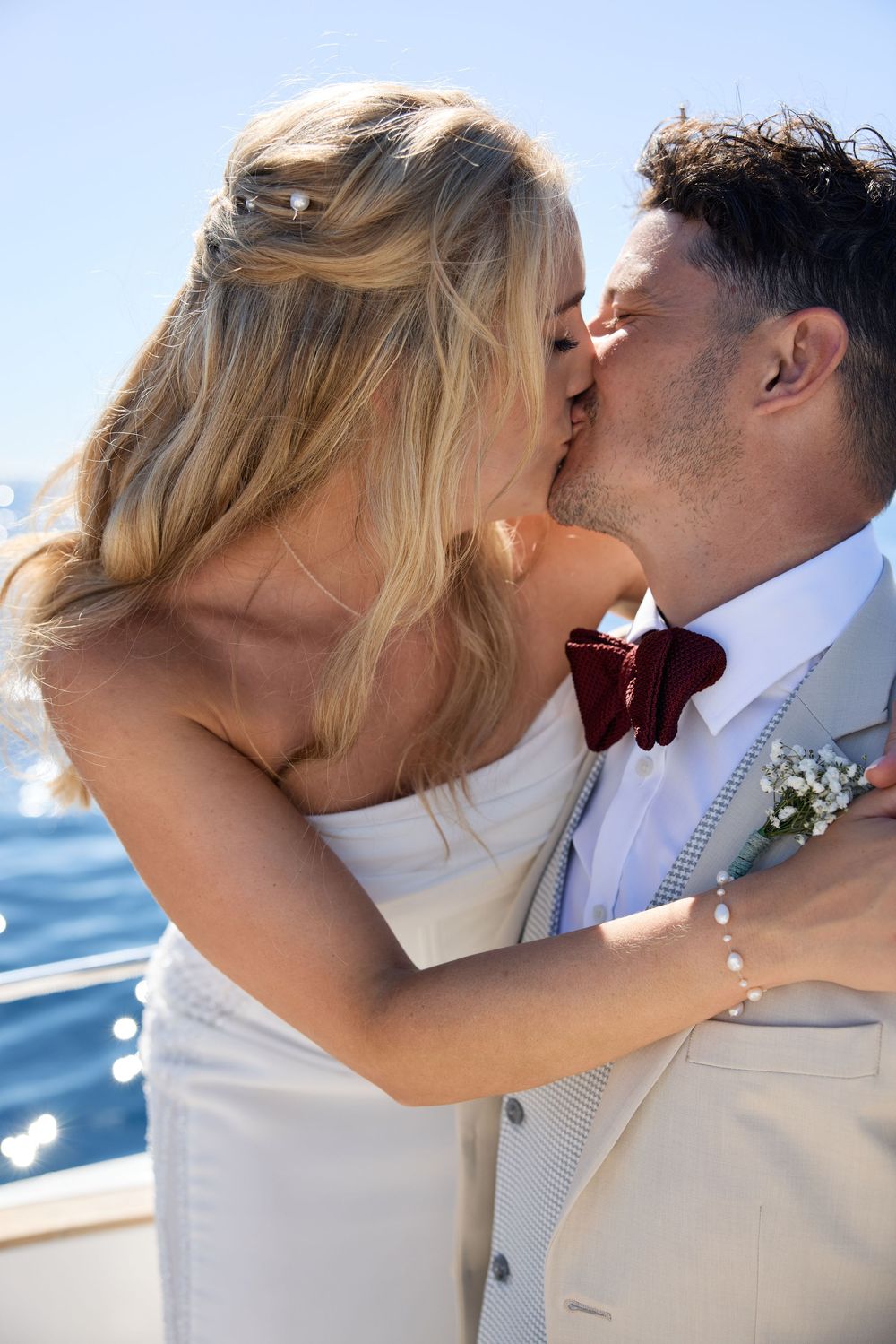 Romantic moment captured on a boat with sparkling ocean waters in the background.