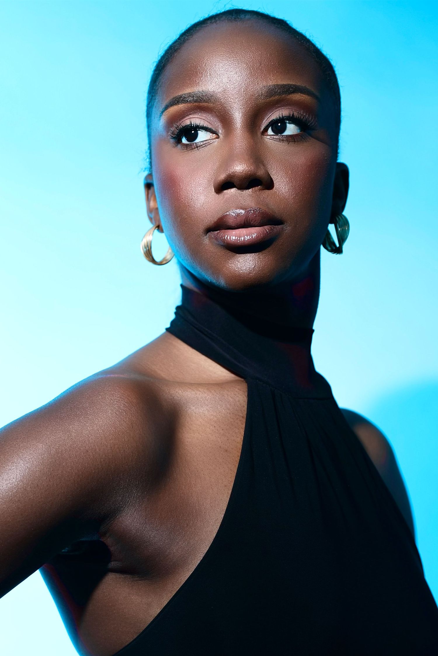 Fashion beauty portrait against blue background showing dramatic angles and lighting effects.