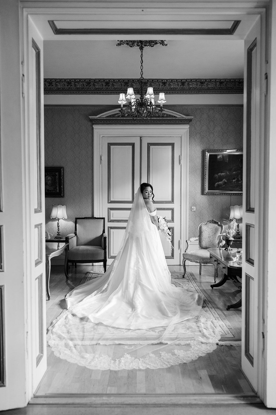 A series of black and white photographs showing a wedding dress displayed in different rooms of an elegant interior space.