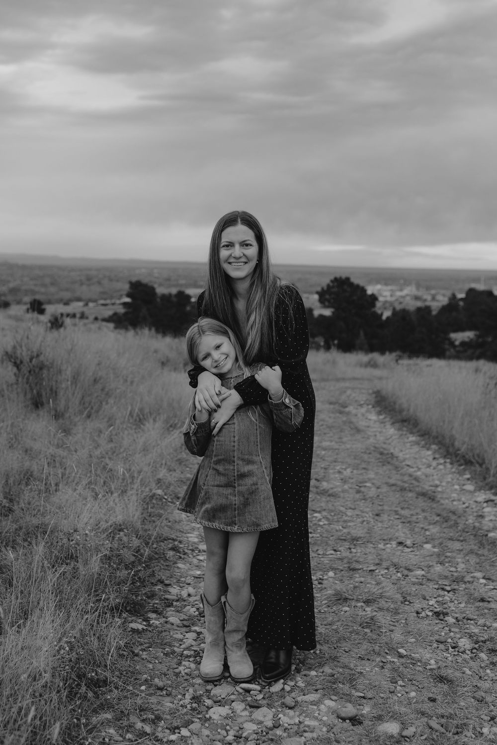 Black and white photo of people enjoying a moment together on a path surrounded by natural landscape.