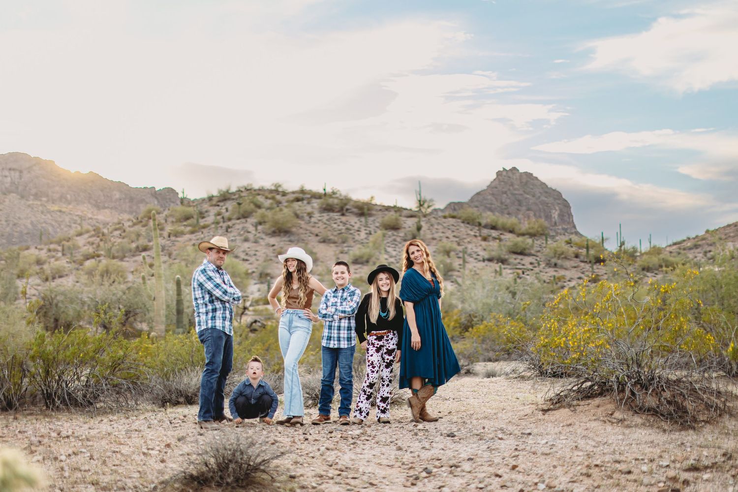 Desert landscape family photography session with mountains and cacti in background.