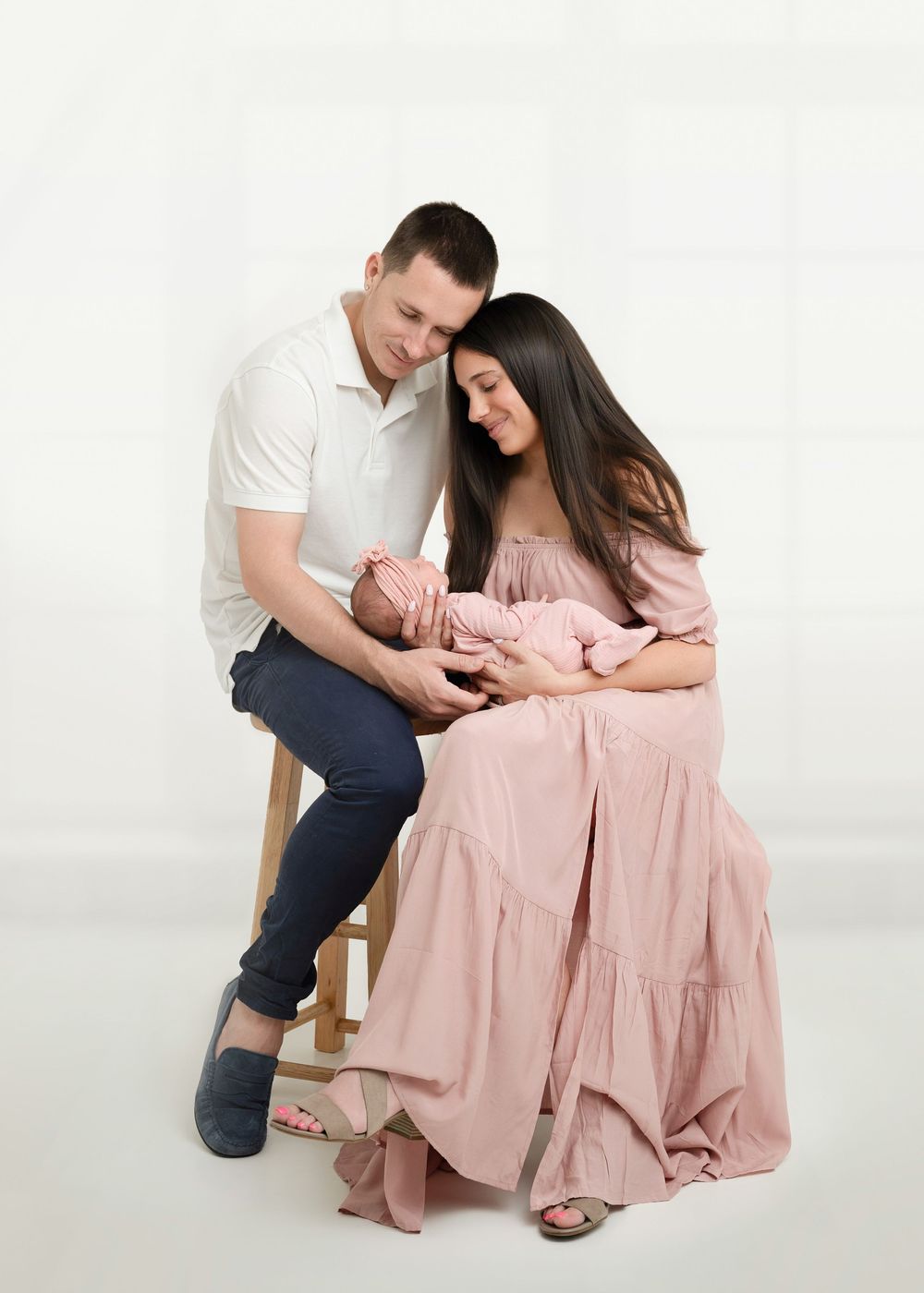 A couple in casual attire shares an intimate moment while sitting on a white background in a three-photo sequence.
