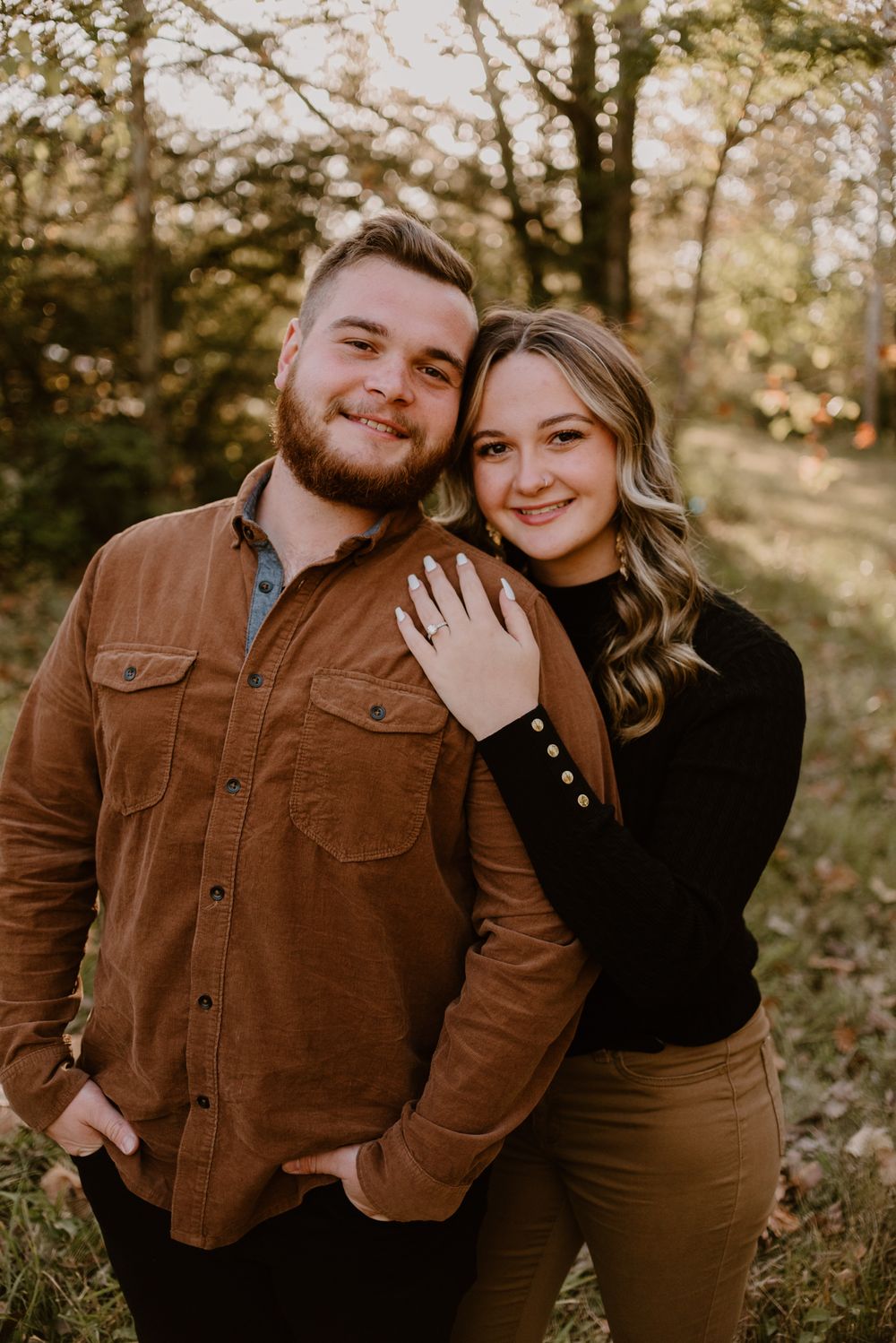 Warm autumn portrait series of a couple in coordinating brown outfits against natural backdrop.
