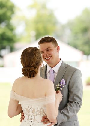 A romantic first look sequence between newlyweds under an outdoor pavilion.