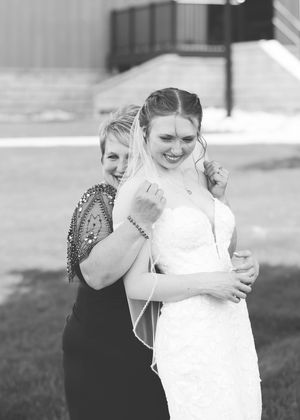 A tender black and white moment shared between a bride in white and her mother.